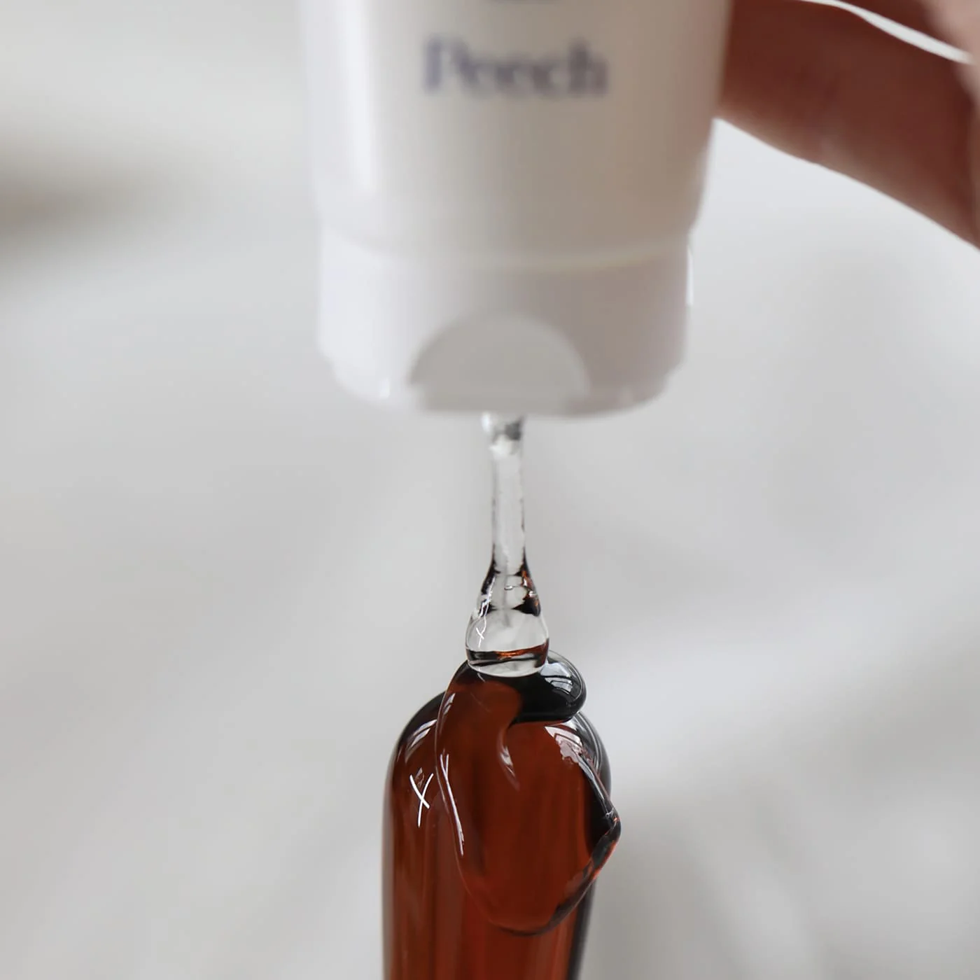 Billede af glidecreme der bliver hældt over en glas dildo.
