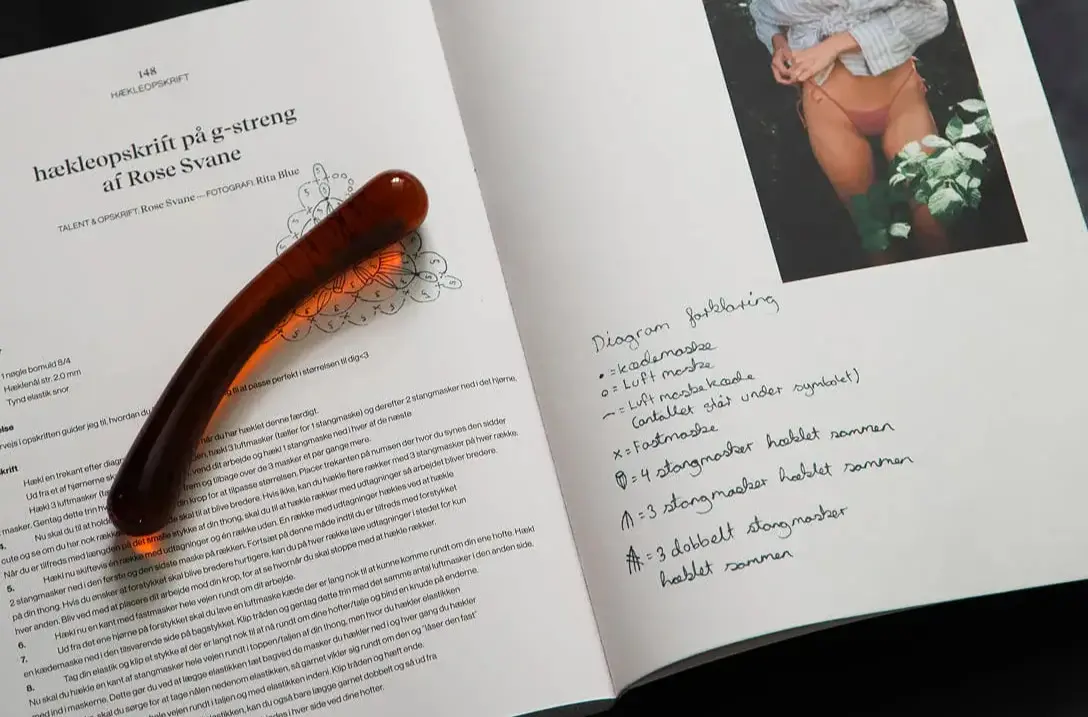 Glas dildo placeret på bog